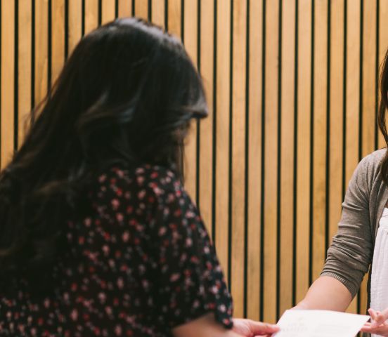 A greeter welcoming someone at the welcome table
